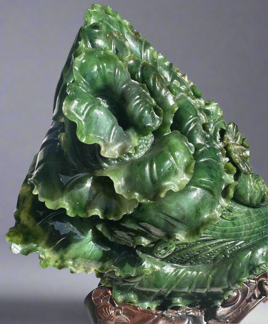 One of a kind hand carved Canadian jade Chinese cabbage sculpture on an ornate wooden stand.
