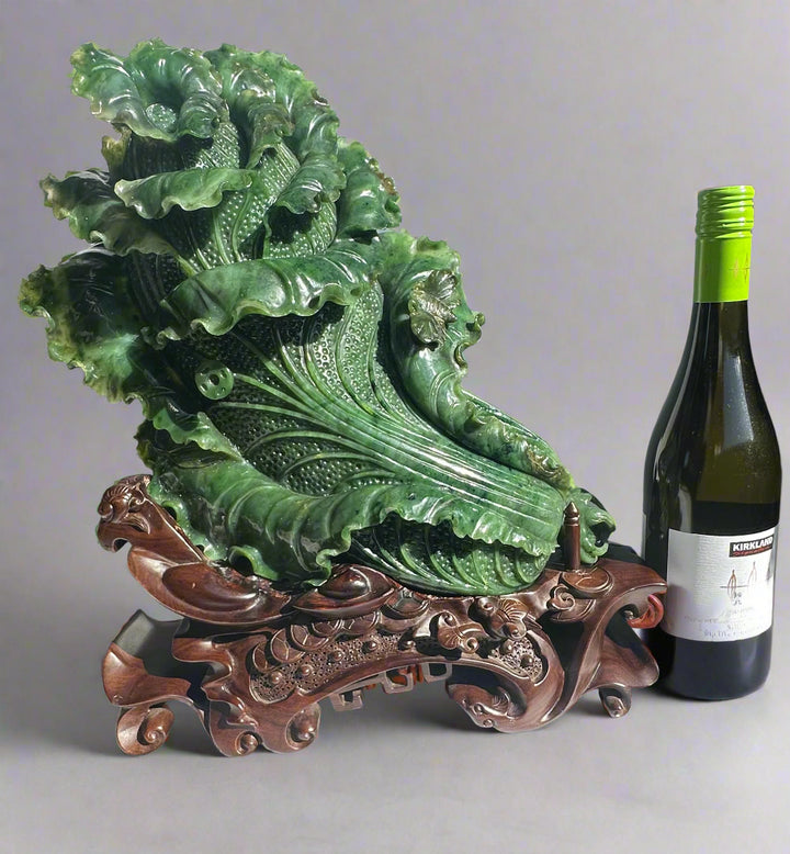 Large Canadian Jade Chinese Cabbage sculpture on an ornate carved wood stand with a wine bottle for scale