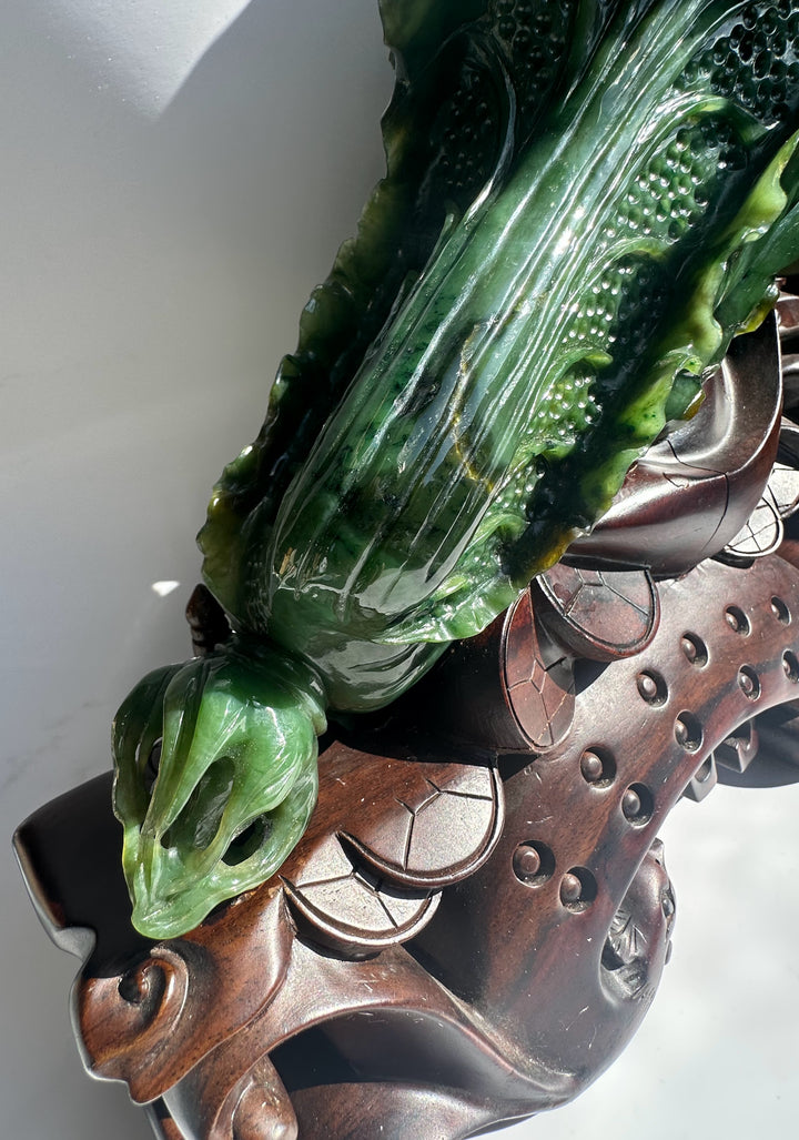 Large Canadian jade Chinese cabbage sculpture with detailed leaf textures on a carved wooden stand.