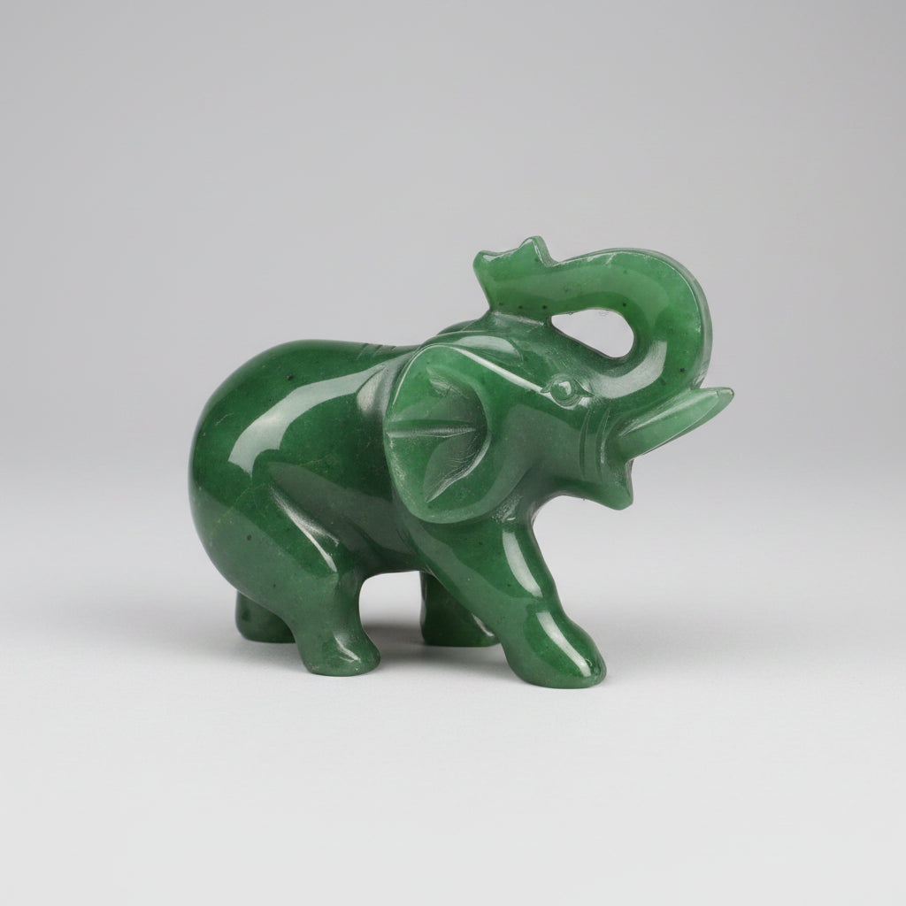 A polished green jade elephant figurine standing on a grey studio background