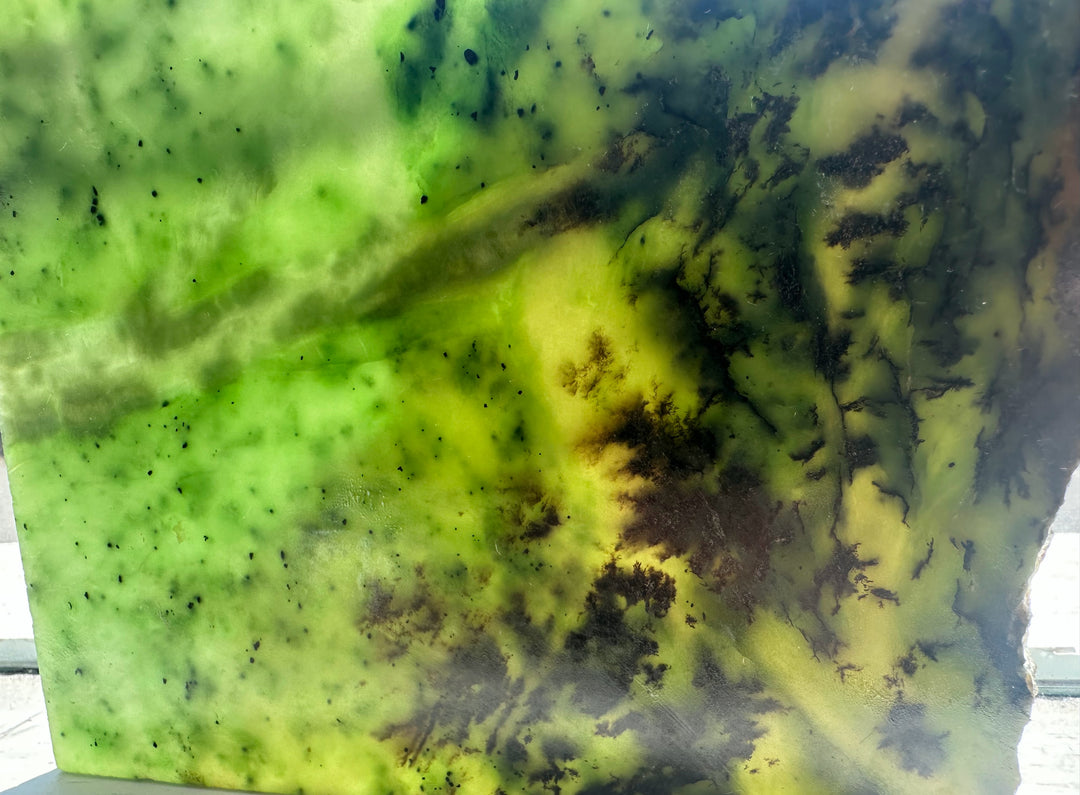 A square stone slab or tile featuring a marbled pattern of vibrant green, yellow, and dark brown/black veins, jade