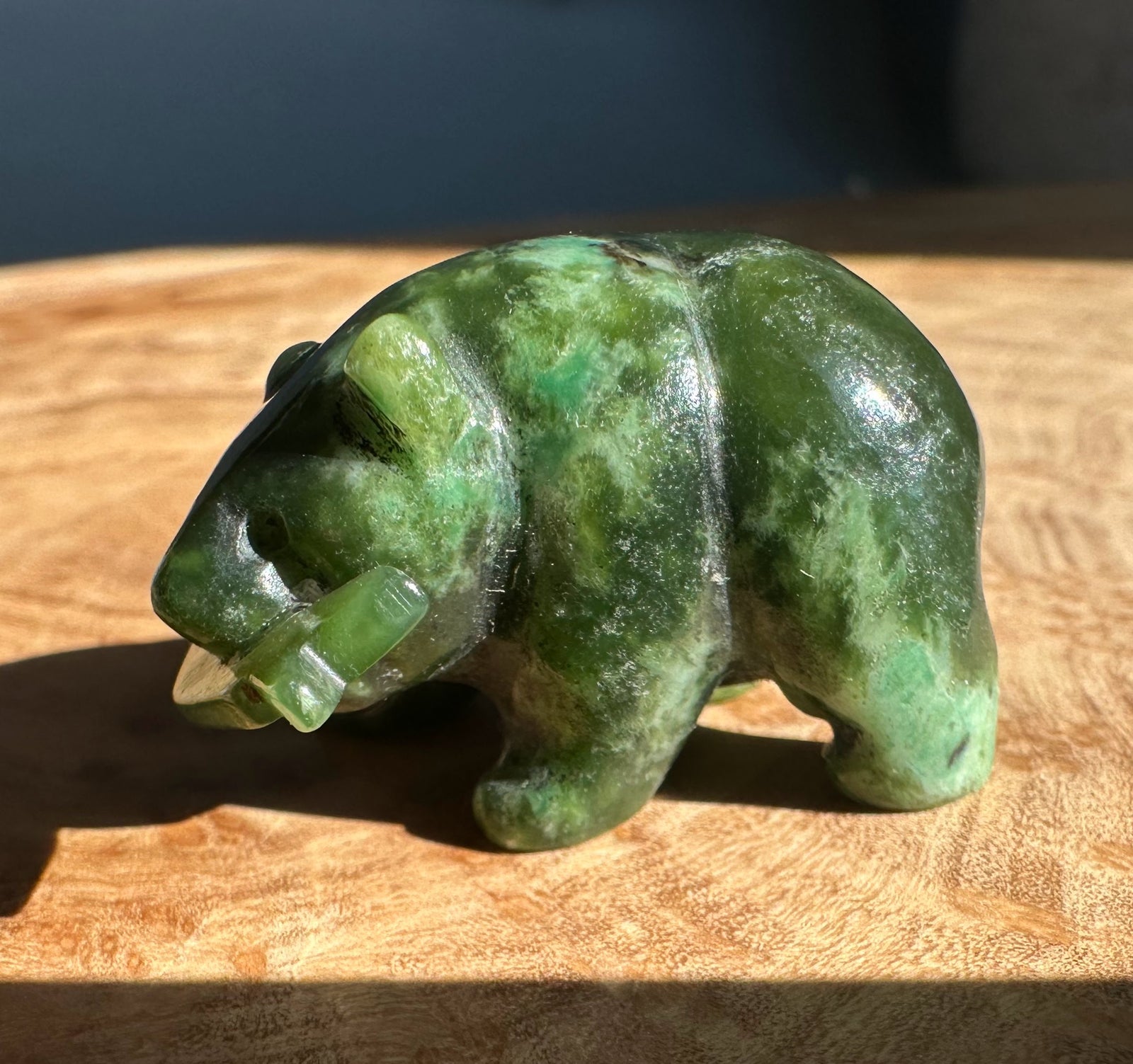 Green jade bear sculpt with a jade fish detail carved on its side