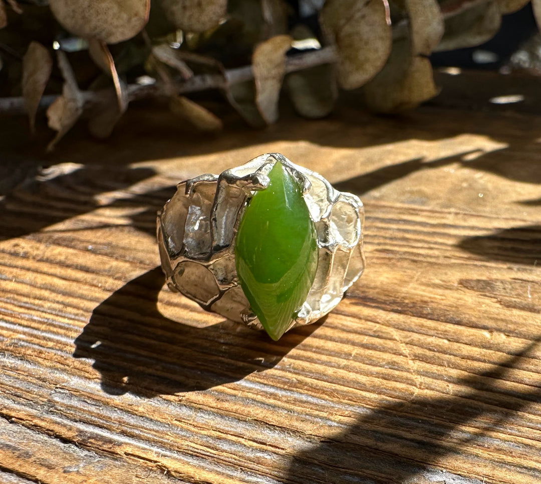 Hammered silver ring with a green jade cabochon set in an irregular rugged bezel