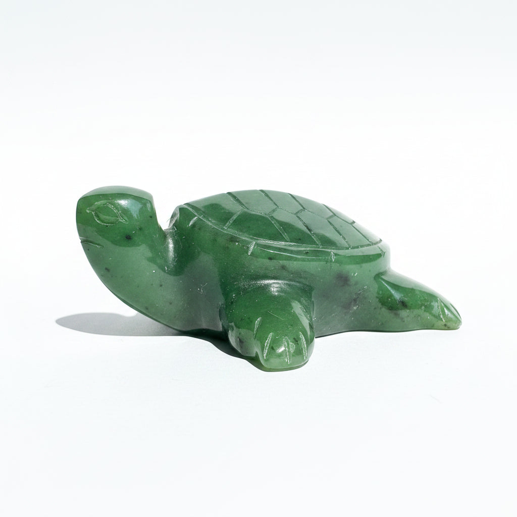 A small carved green turtle figurine made of polished Canadian Jade, resting on a white neutral background.