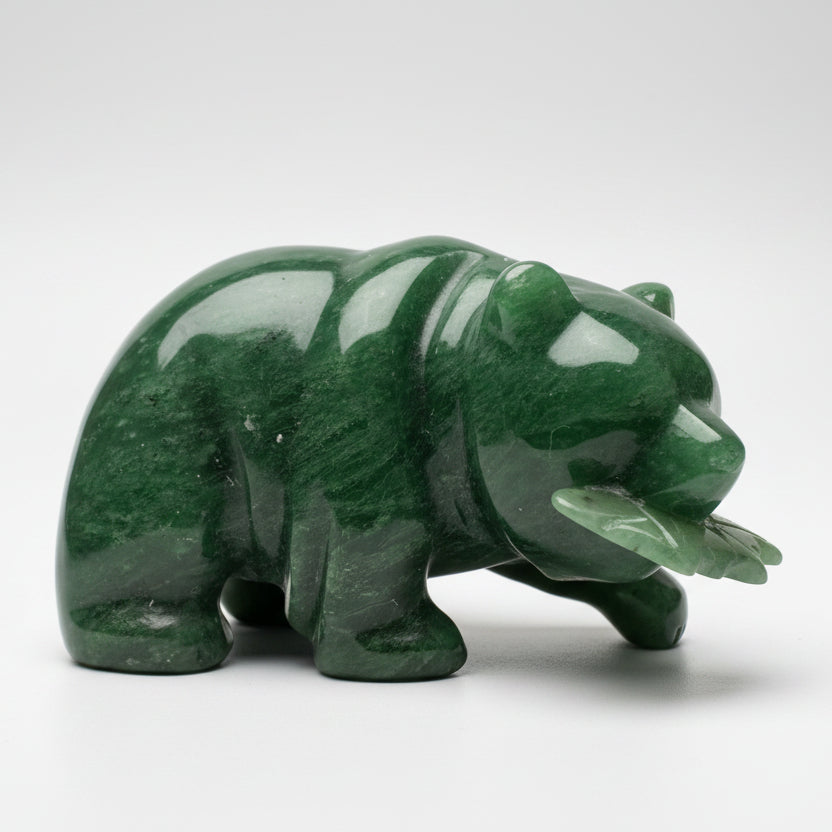A polished green jade bear figurine holding a fish, displayed white grey background.