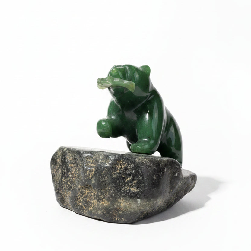 Jade Bear holding a jade fish in its mouth, standing on a granite base, with a white background