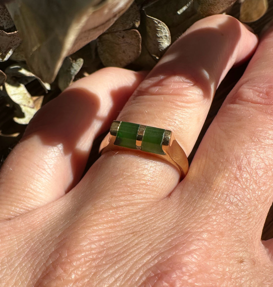 Gold ring with two rectangular green jade stones set side by side on a gold band