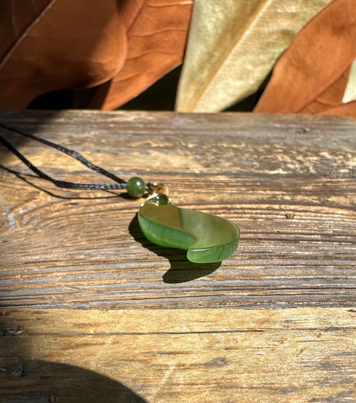 40mm curved nephrite jade pendant on a black cord with a green bead