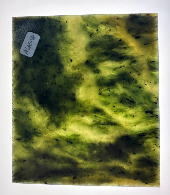 A square glass plate featuring a marbled pattern of olive green, yellow-green, and dark blackish veins, with a small white label reading &