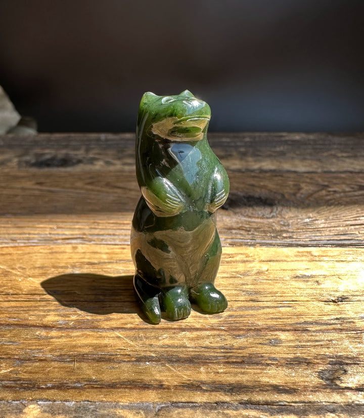 Canadian jade otter figurine carved in green tones resting on a wooden surface