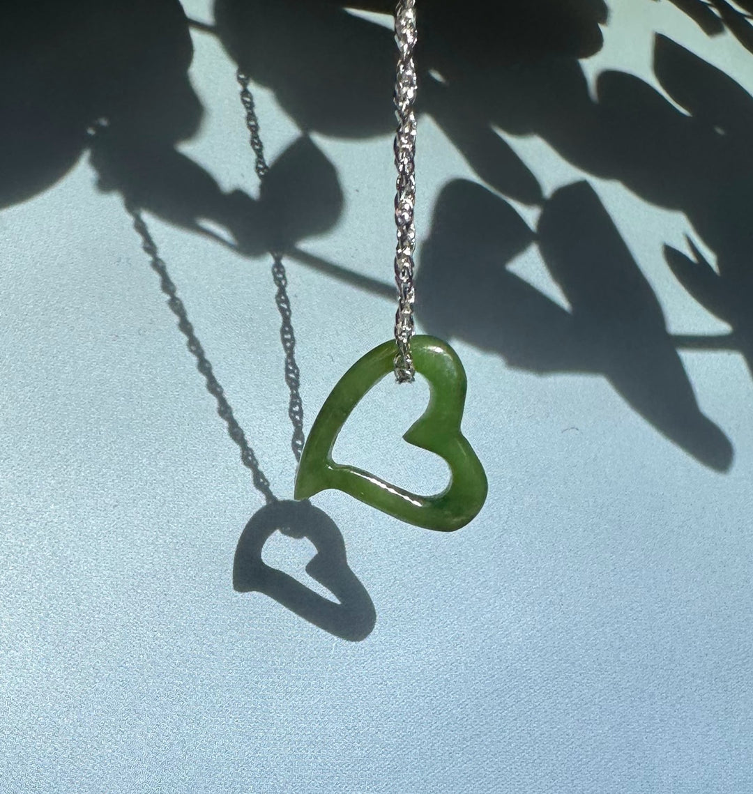 Floating jade heart pendant with two hearts on a silver chain a solid larger heart and a smaller hollow heart
