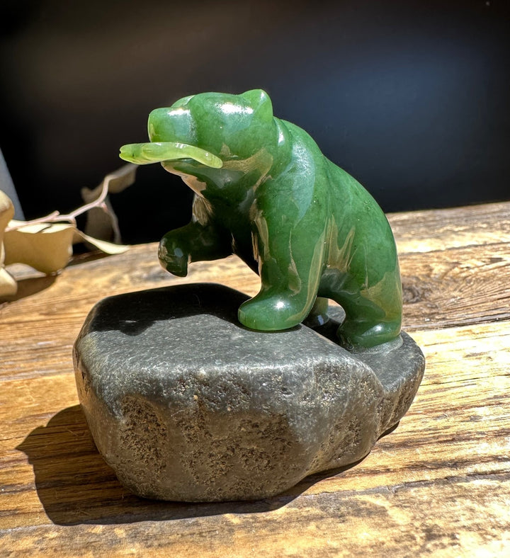 Two inch green jade bear on a gray granite base