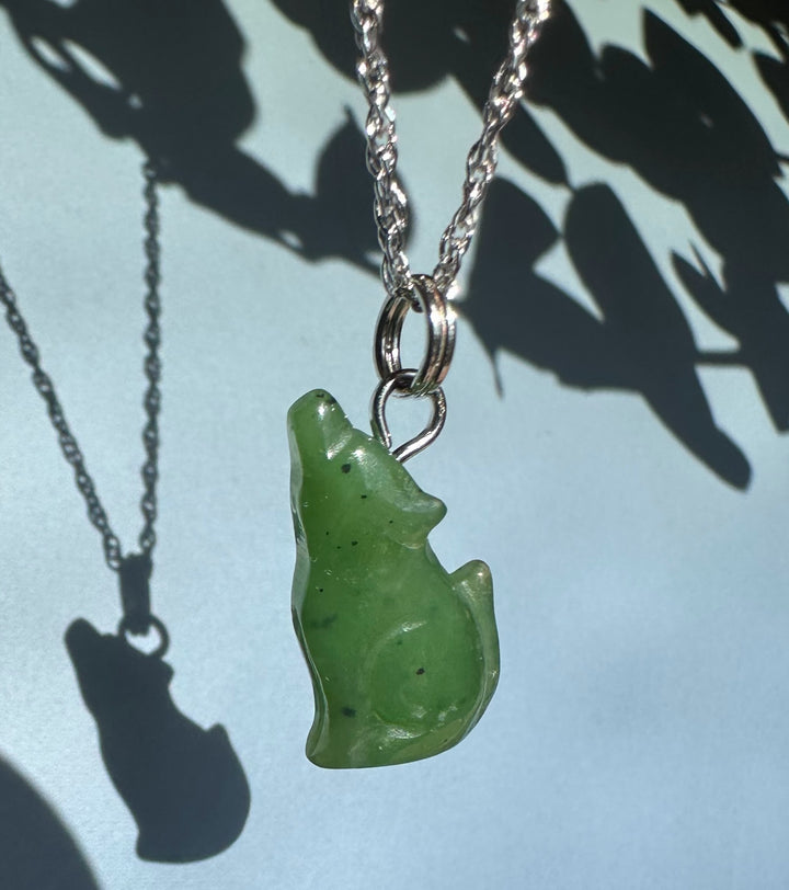 Green wolf shaped pendant on a silver chain