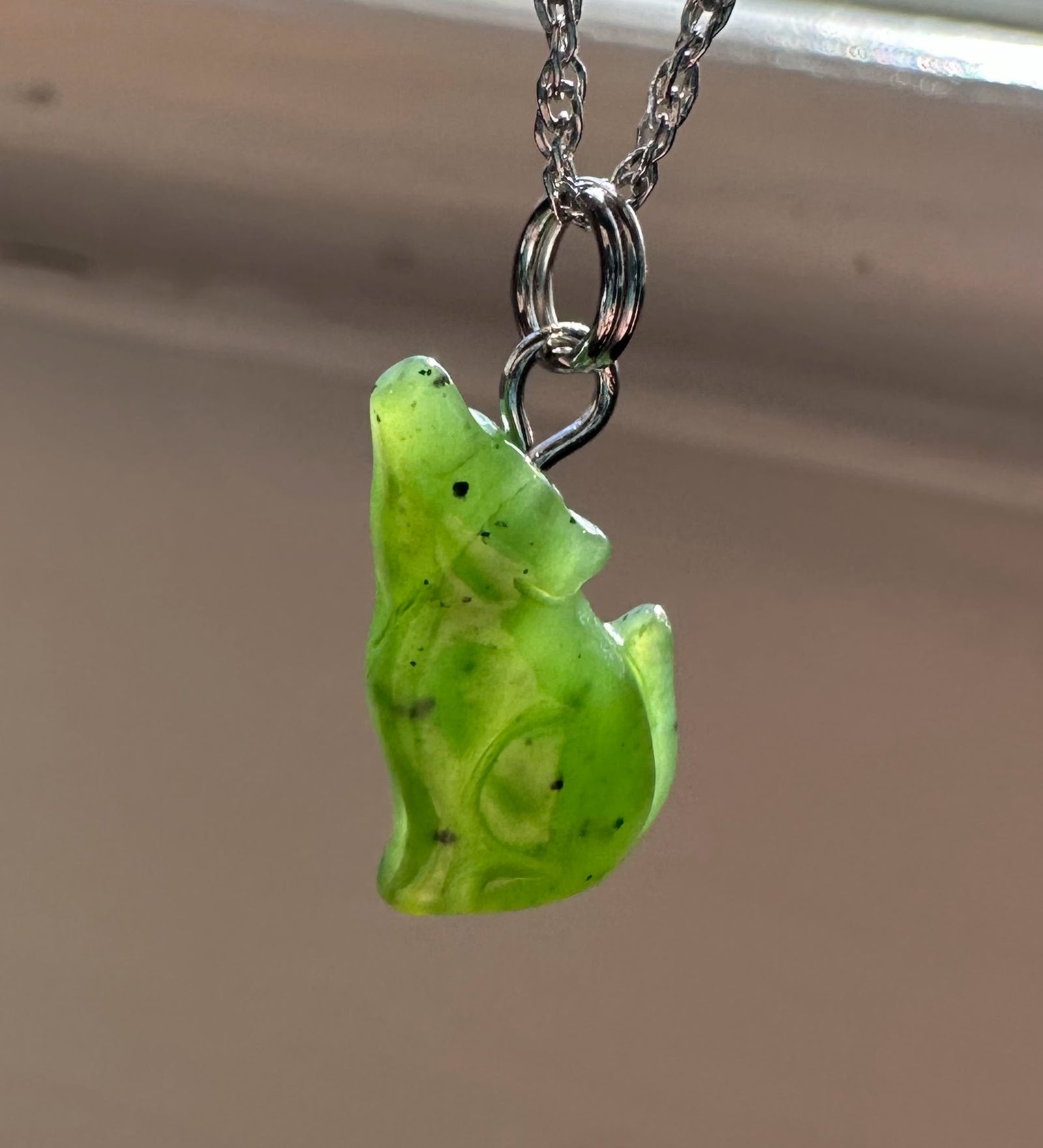 Green wolf shaped gemstone pendant on a silver chain