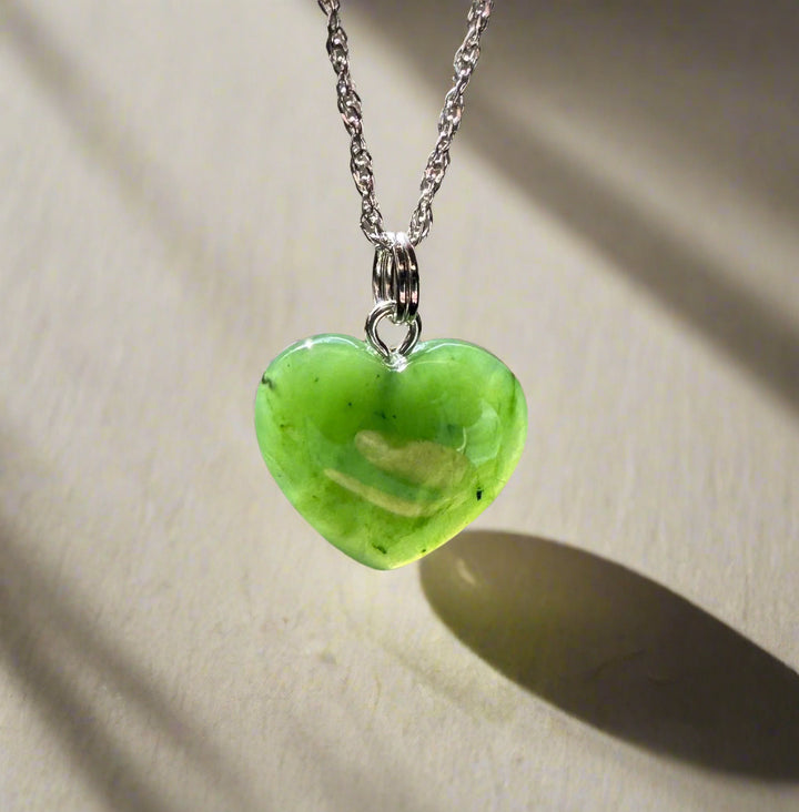 Solid green jade heart charm on a silver chain