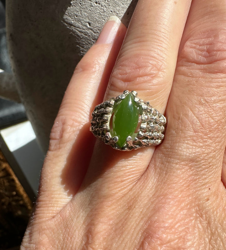 Vintage Jade Ring on finger featuring a marquise green jade centerpiece and a chunky silver lattice band.