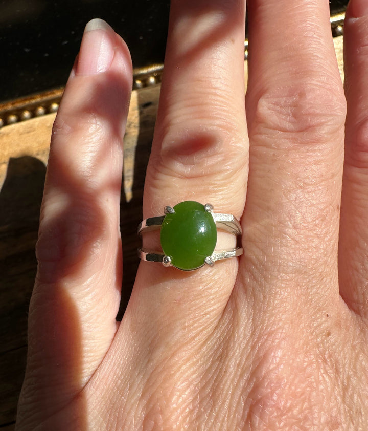Silver ring with oval green jade worn on the finger