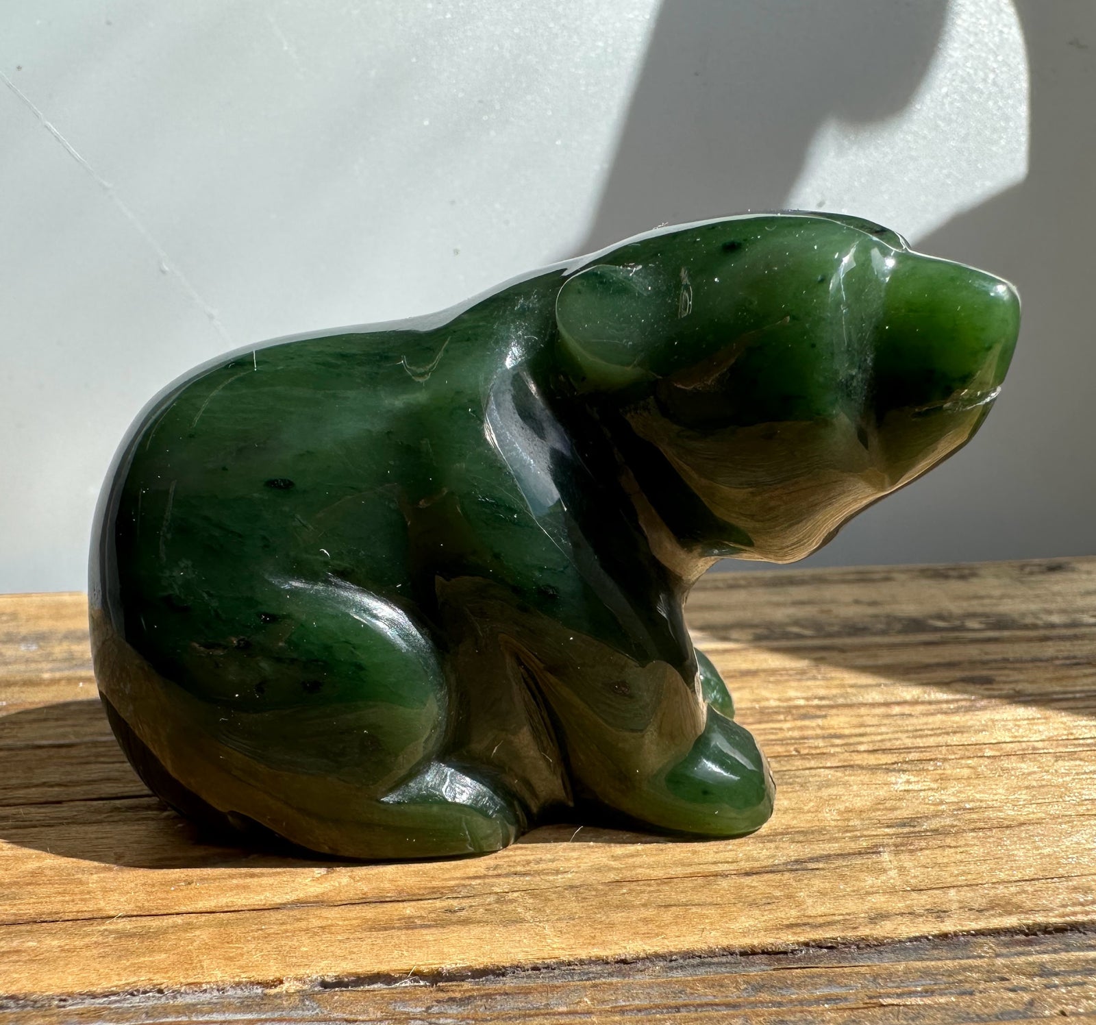 Side profile of a glossy green Canadian jade bear sculpture