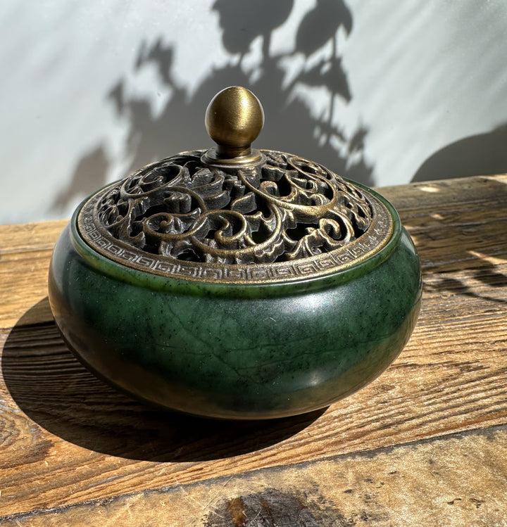 Close up of the jade burner showing the decorative bronze lid with intricate scrollwork and a brass knob.