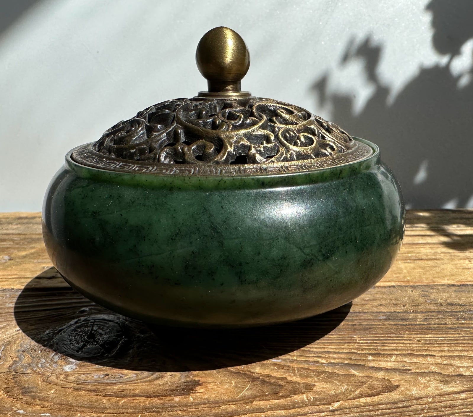 Nephrite jade incense burner with a rounded bronze lid featuring an intricate openwork pattern and a brass knob