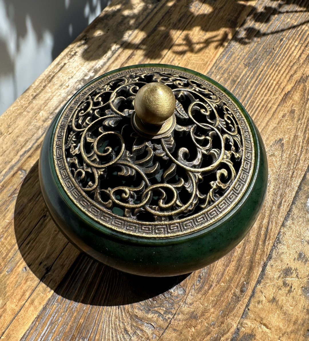 Top view of nephrite jade incense burner featuring an ornate bronze lattice lid and a round brass knob.