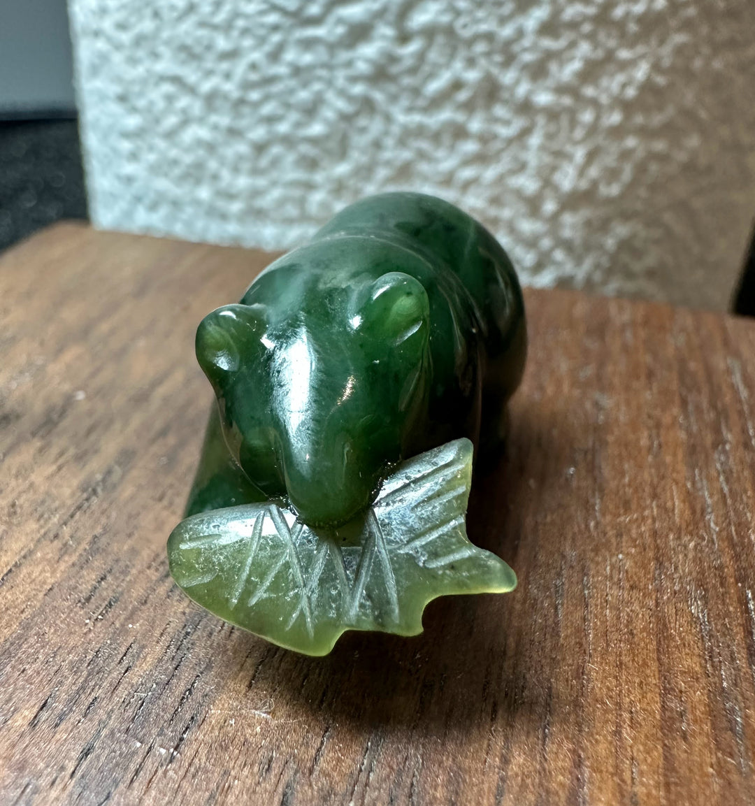 Green jade bear on a pale carved leaf base