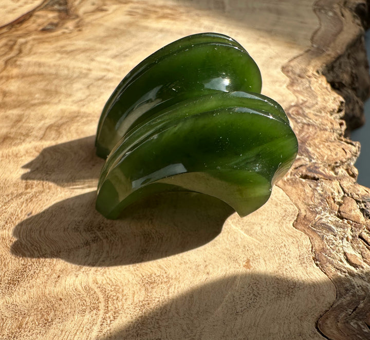 Canadian jade carved crescent earring components stacked on a wood surface.