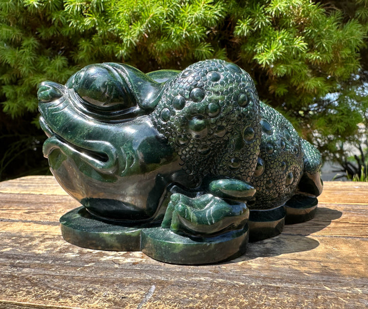 Dark green Ogden Jade Toad sculpture 5.25 inches resting on a weathered wooden surface outdoors.