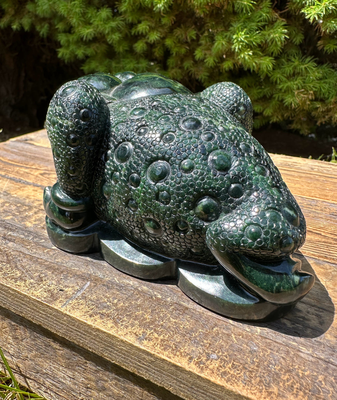 Front angle of the dark green Ogden Jade Toad statue with a wide smiling mouth and textured bubbled skin.