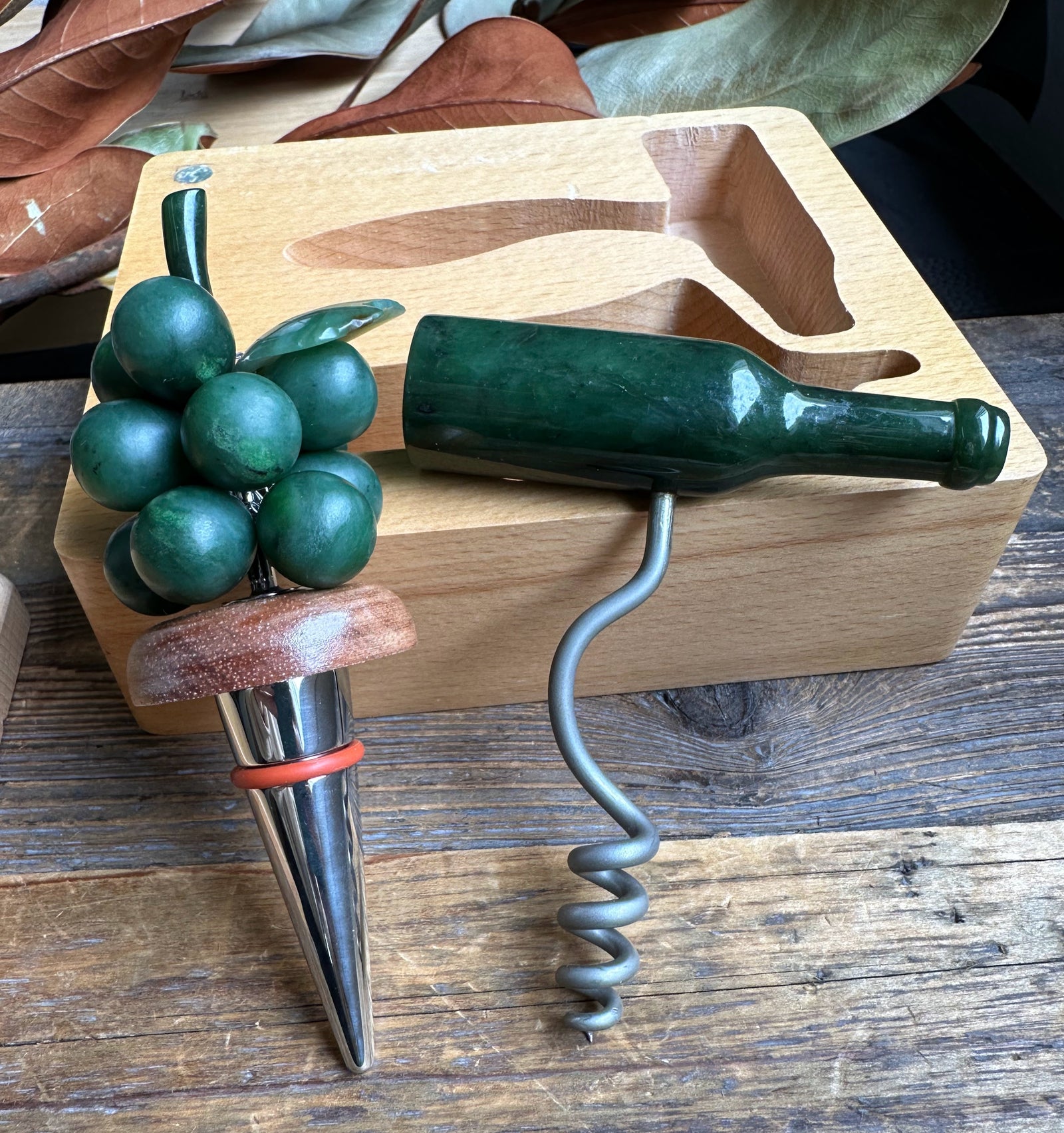 Jade Wine Set with a green bottle shaped corkscrew and grape cluster handle on a natural wood tray