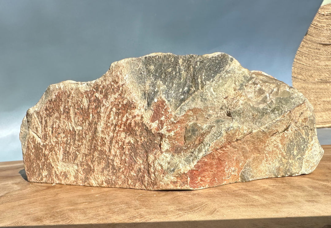 Wyoming rock specimen with red and gray banding resting on a wooden surface