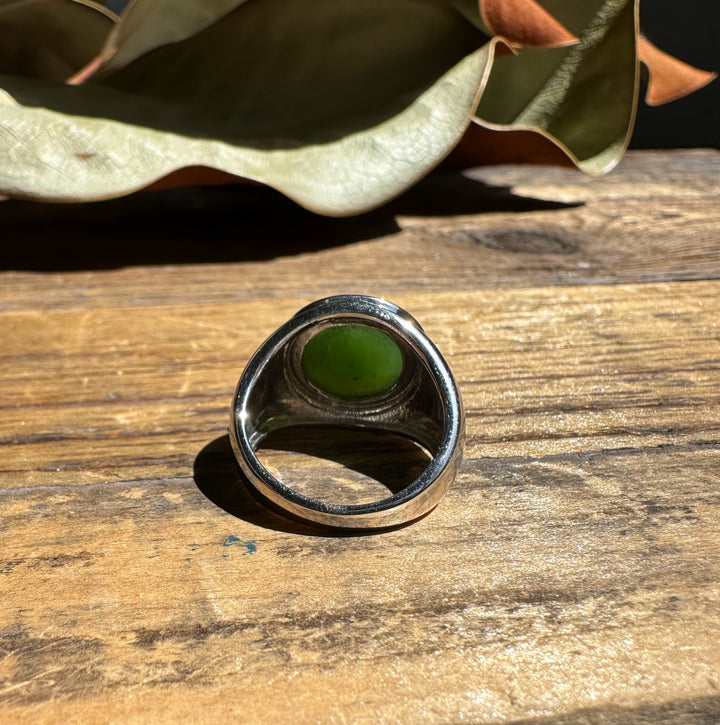Side view of the silver ring featuring a green jade cabochon set in a rounded bezel.