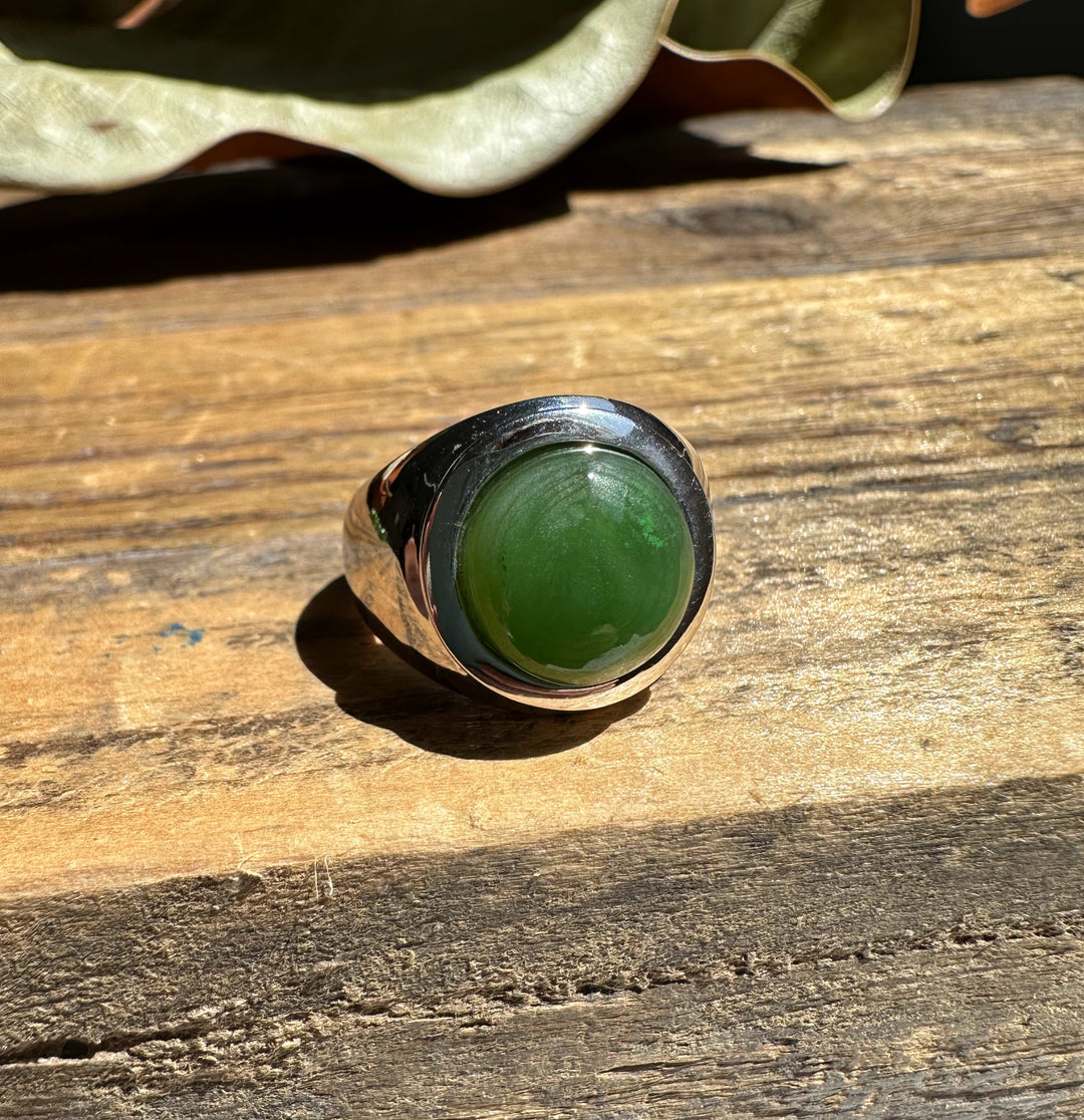 Canadian Jade Ring with green jade cabochon in a bold silver bezel on wood.