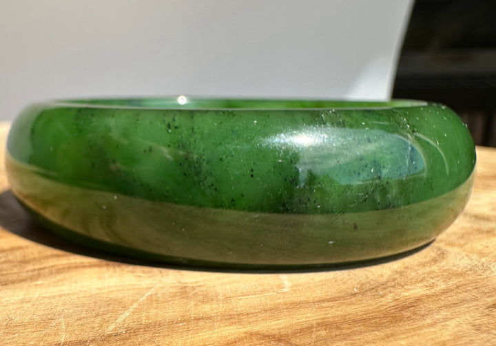 Jade bangle 57 x 17mm viewed from the side, showing vivid green color and glossy finish