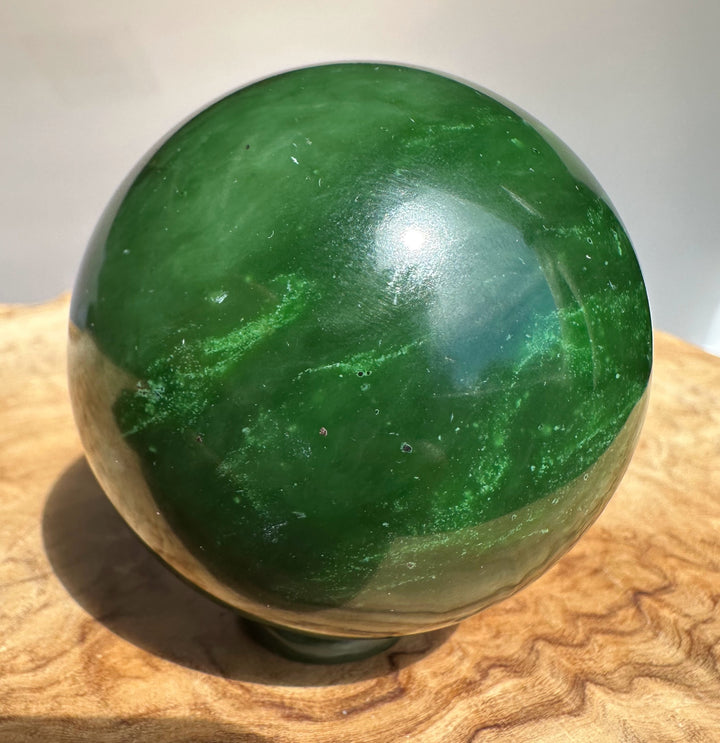 Canadian jade sphere 63mm polished green with dark natural inclusions