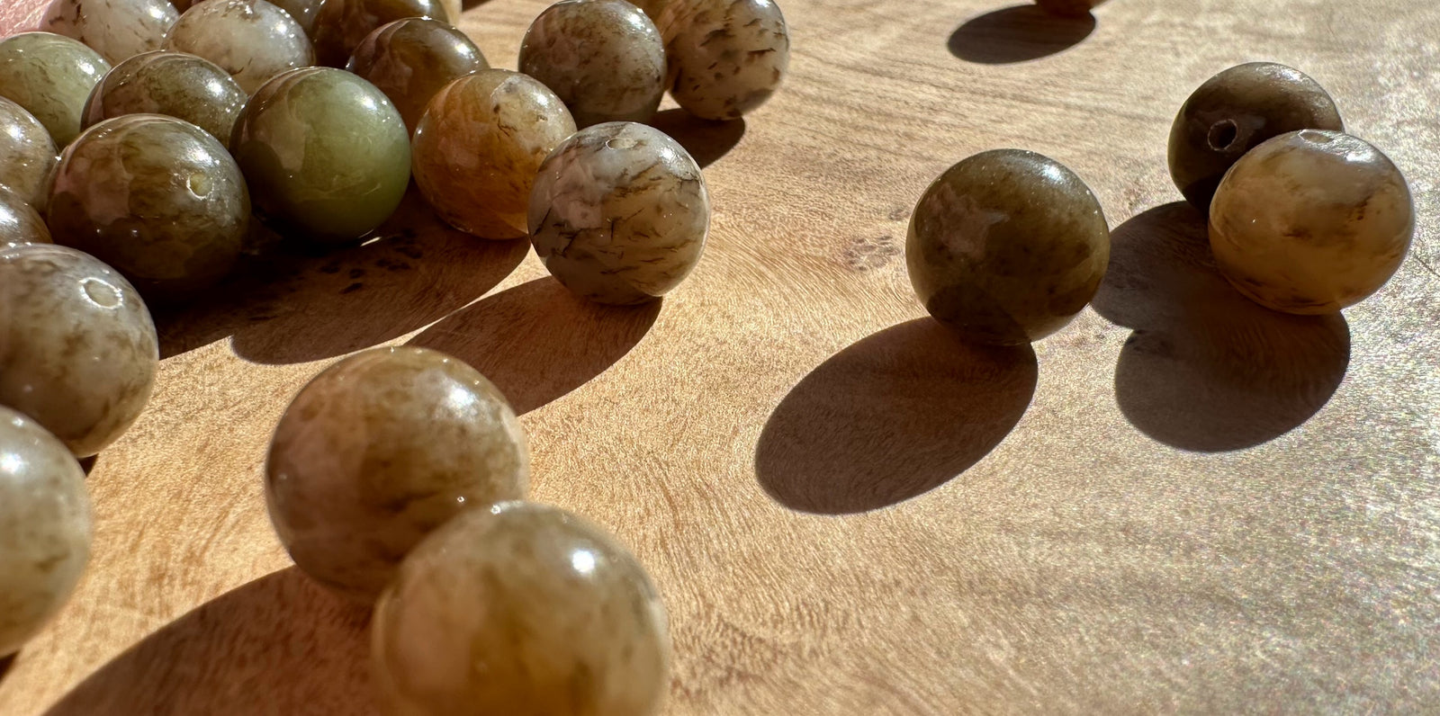 Polished 10mm Siberian nephrite jade beads in earthy beige and gray marbling
