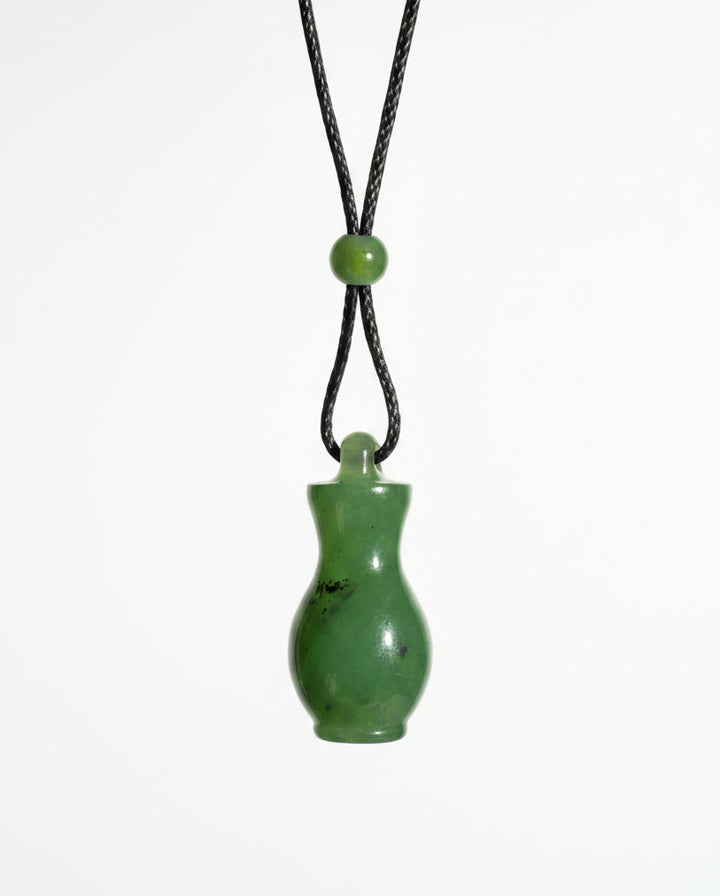 A small green jade bottle pendant on a black cord, white background