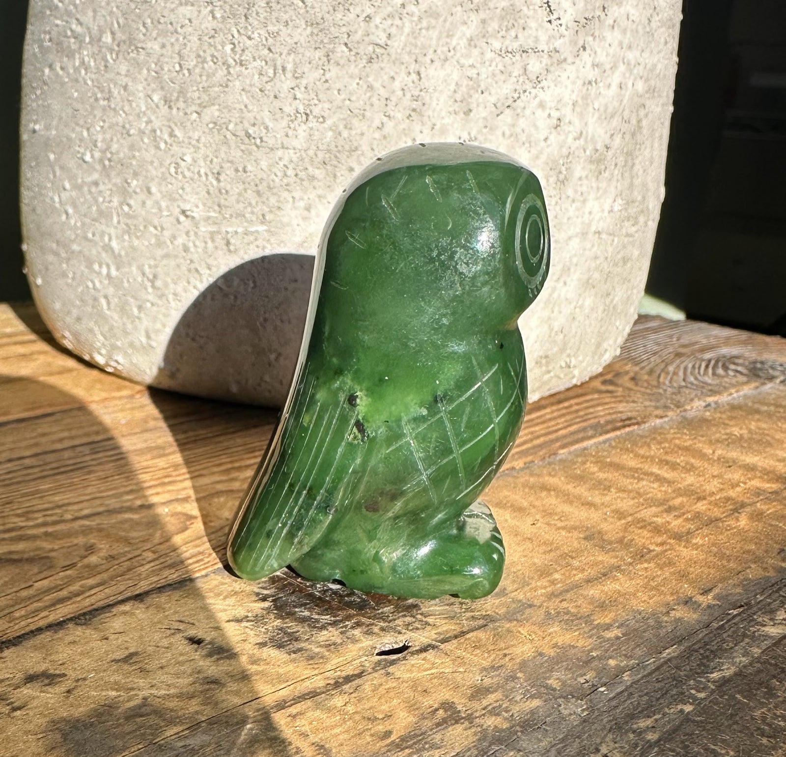 2-inch Canadian jade owl figurine in green on a weathered wood surface