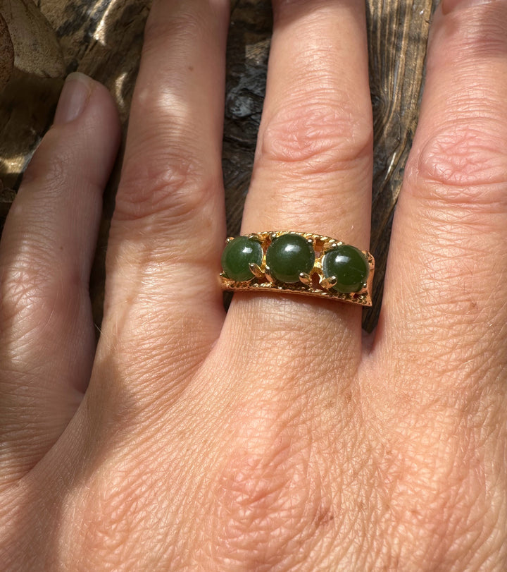 Gold vintage ring with three round jade beads worn on the finger