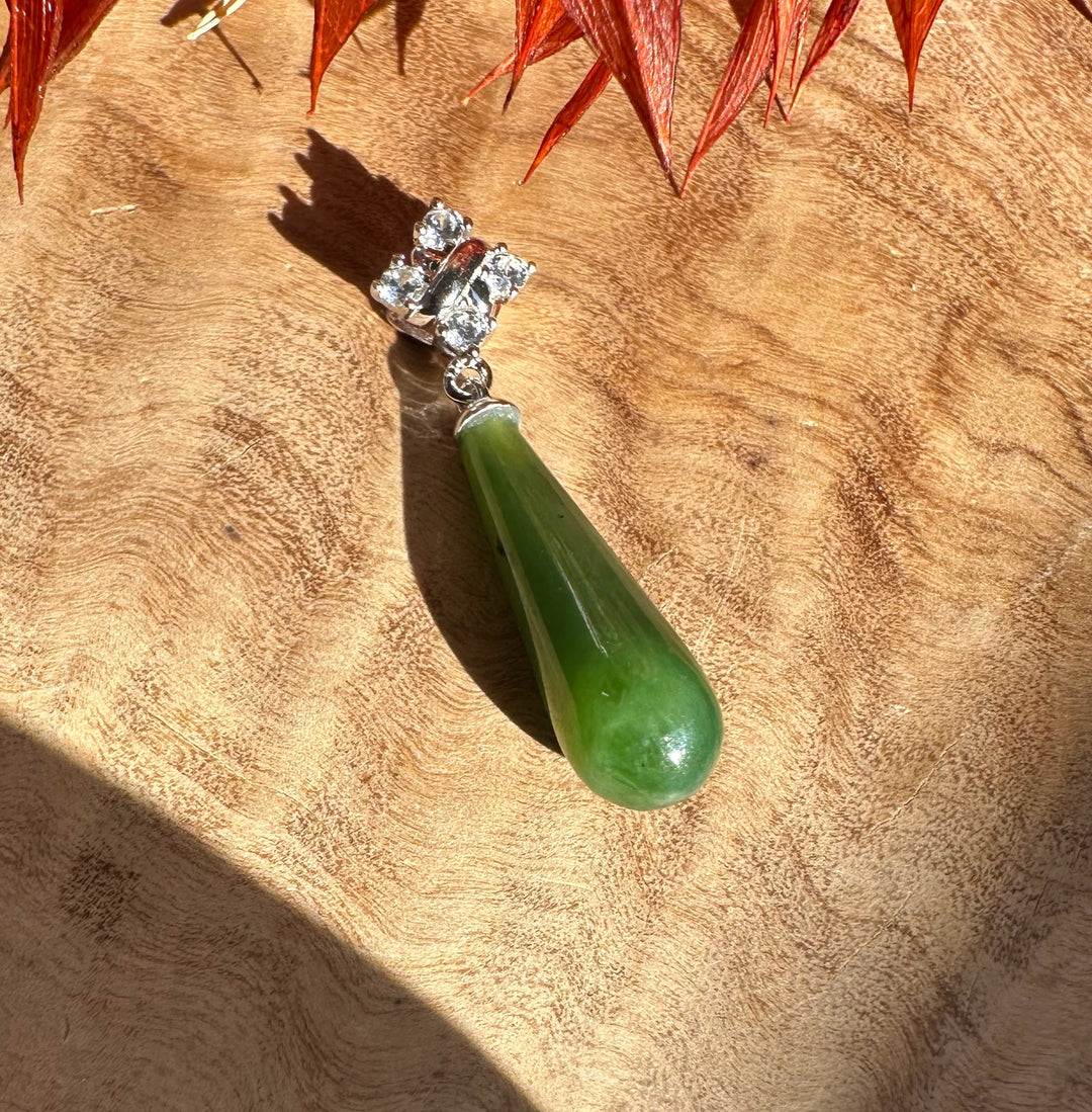 Silver chain pendant with a diamond cluster above a green nephrite jade teardrop
