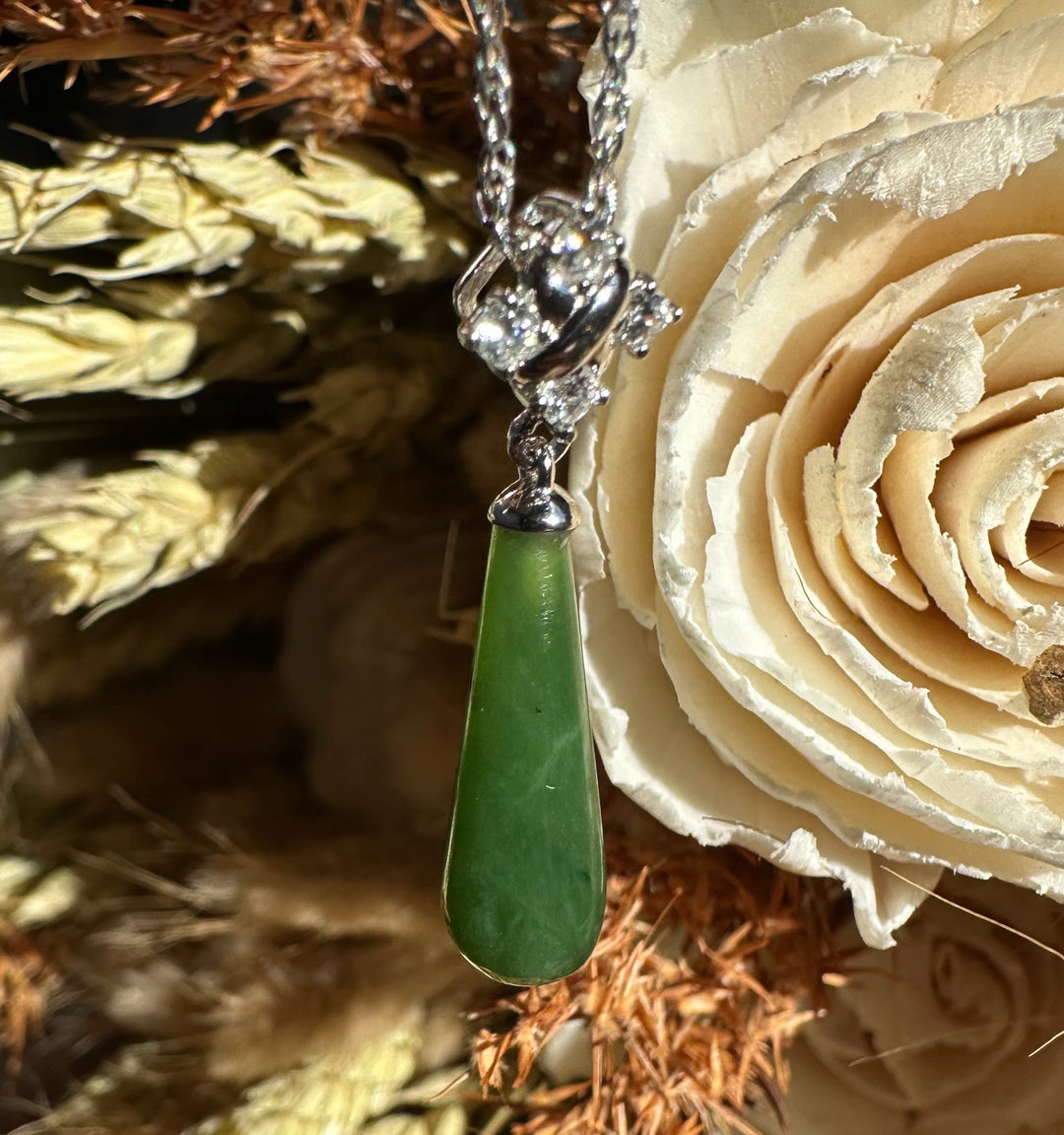 Teardrop green nephrite jade pendant with a silver cap on a delicate chain