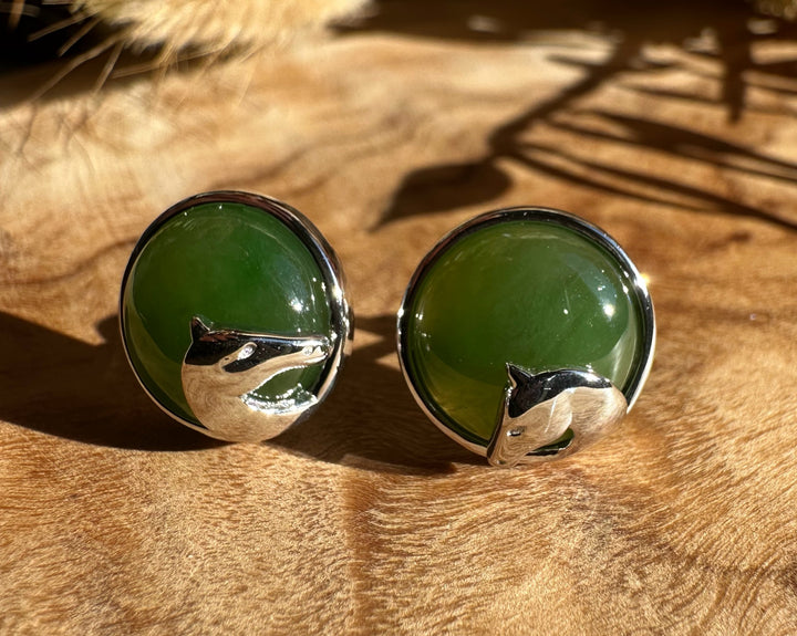 Round green jade stud earrings with a polished silver setting and horse head detail.