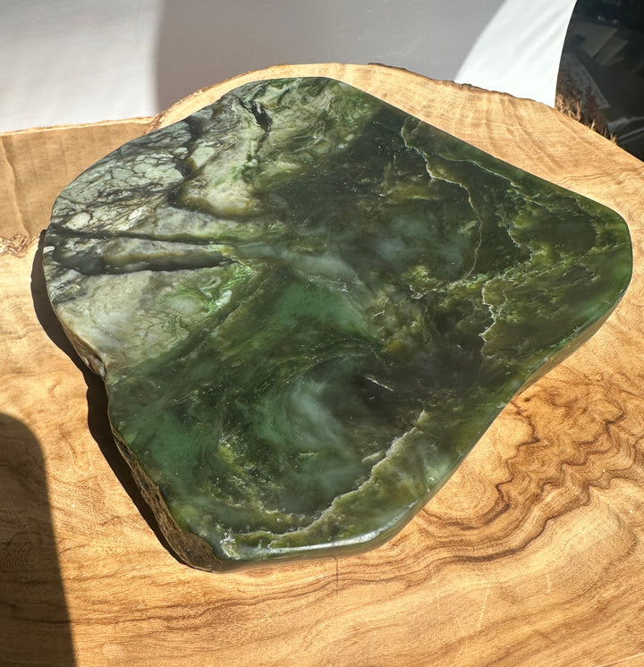 Close up of the Jade Dish featuring deep green stone with intricate white veins on a wooden backdrop