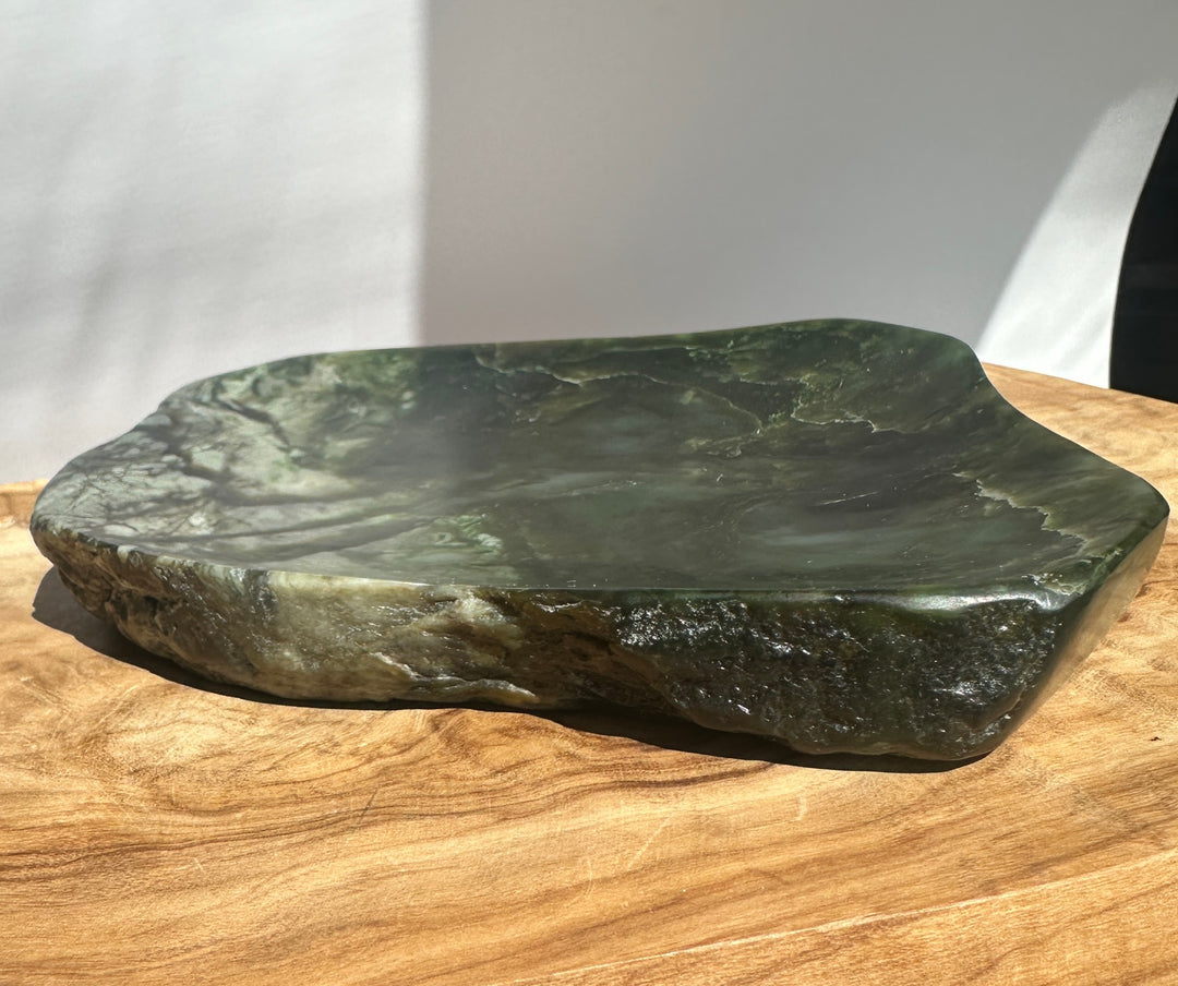Canadian Jade Dish resting on a wood surface with dark green marbled stone and subtle lighter veining