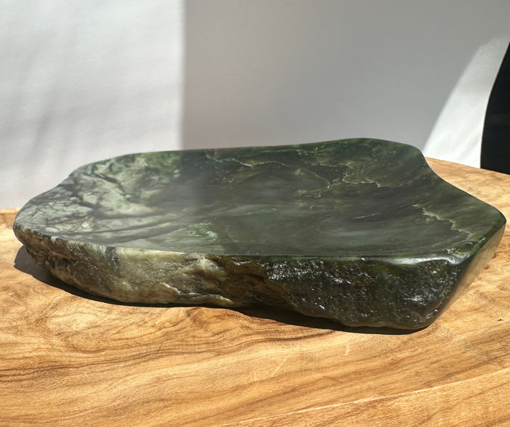 Canadian Jade Dish resting on a wood surface with dark green marbled stone and subtle lighter veining