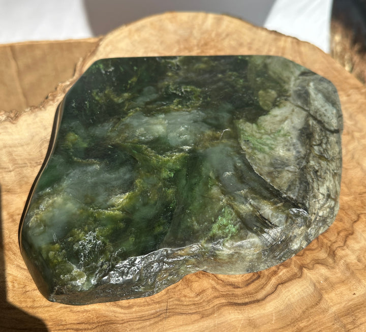 Top edge view of Canadian Jade Dish resting on a wooden board showcasing green and gray marbling