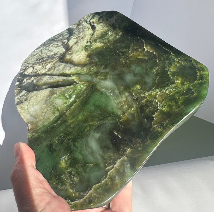 Canadian Jade Dish with dark green marbling held in a hand for scale