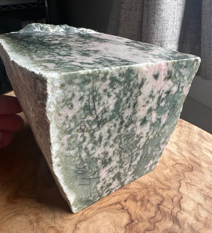 Green and pink wyoming jade and thulite on a wooden base