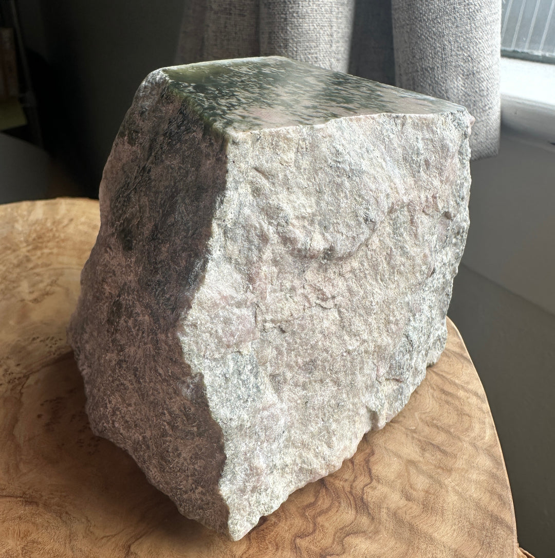 wyoming white green and pink rough on a wooden base beside a windon