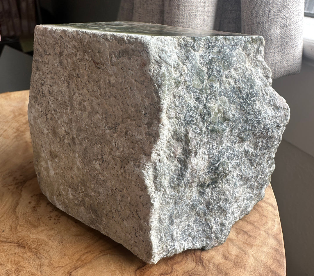 rough wyoming jade outside white skin, on a wooden base